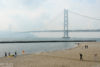 Beachside activities against the backdrop of Akashi Kaikyō, the beautiful suspension bridge in Kobe, Japan.