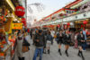 High school girls walking along Nakamise-dori, the shop-lined approach to Sensoji Temple in Asakusa, Tokyo, Japan.