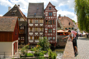Visitors enjoying the view from Häuslesbruck in the historic Fisherman's Quarter (Fischerviertel) in Ulm, Germany.