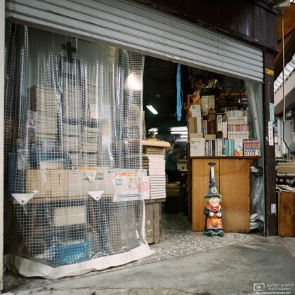 A friendly figure is seen standing beside a bookshelf at an antiques shop inside Gondo shopping street, Nagano, Japan.