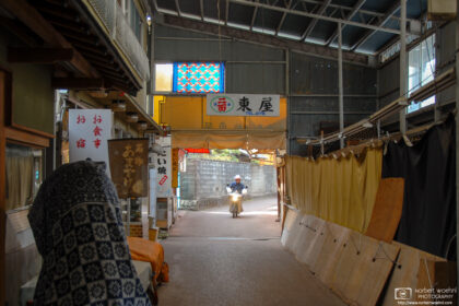 A motorbike is entering Monzenmachi, a historic shopping area along the approach to Saijo Inari Temple in Okayama, Japan.