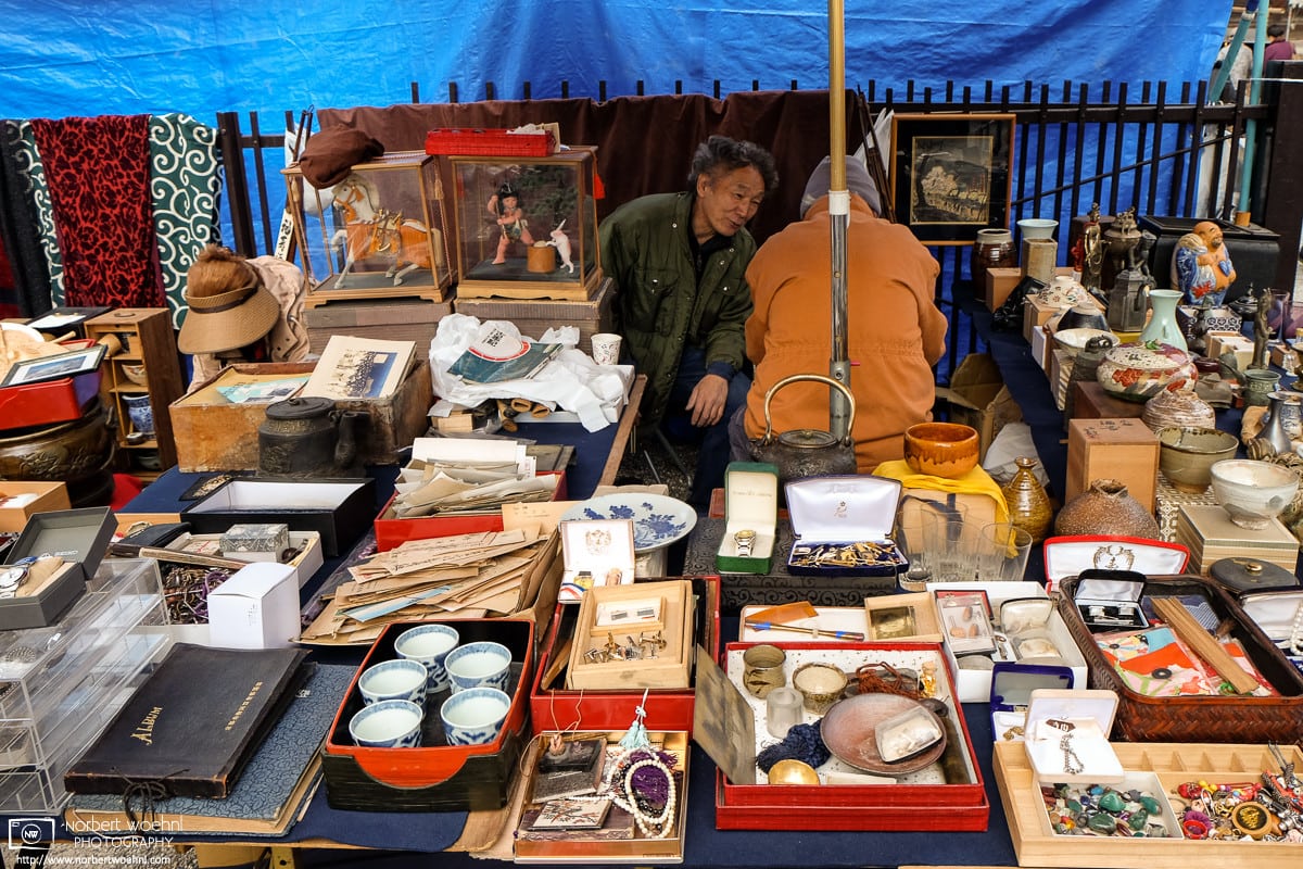 Flea market vendors are having a chat amidst their colorful merchandise at Toji Temple in Kyoto, Japan.
