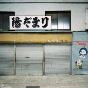 At Gondo Shopping Street in Nagano, an advertisement mural is painted on the wall beside an old shop.