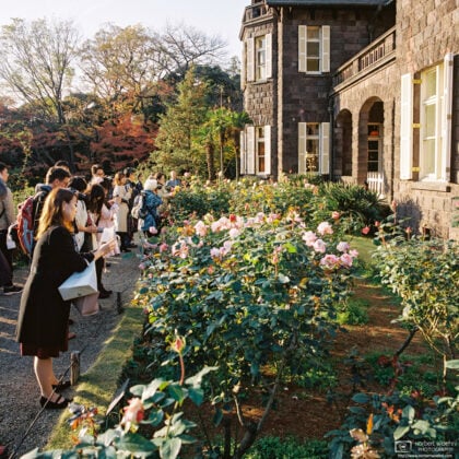 Visitors are watching flowers outside a western-style mansion building at Kyū-Furukawa Gardens in Tokyo, Japan.