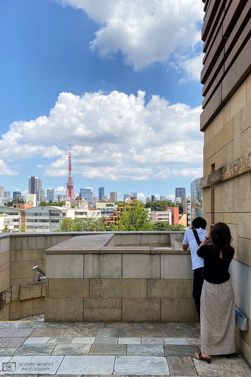 A bright summer day in the Roppongi area of Tokyo, Japan, with Tokyo Tower visible in the distance.