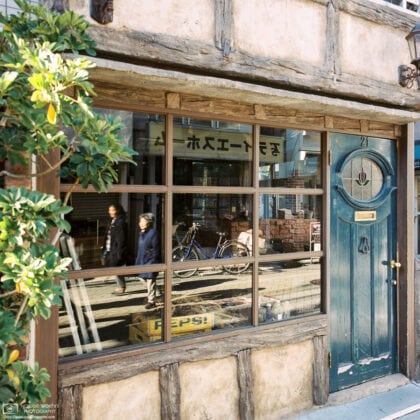 Passersby reflected in a shop window in a shopping street north of Kōenji Station in Tokyo, Japan.